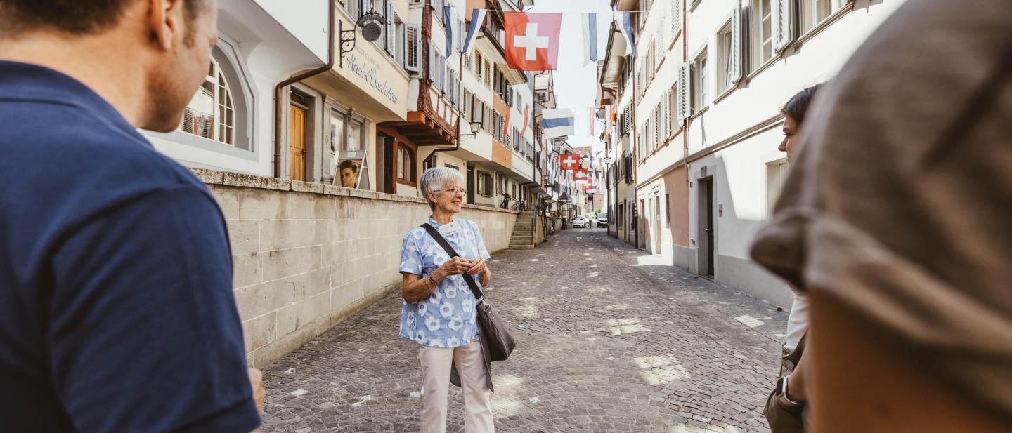 Eine Stadtführerin weiht eine Gruppe in der Zuger Altstadt in die Geheimnisse der Stadt ein.